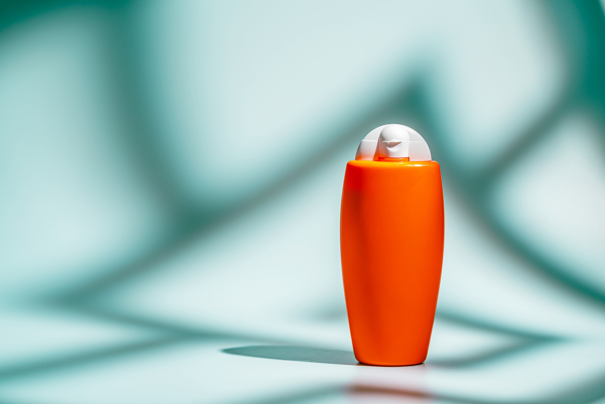 Sunscreen bottles and tubes on a beach towel in sunlight