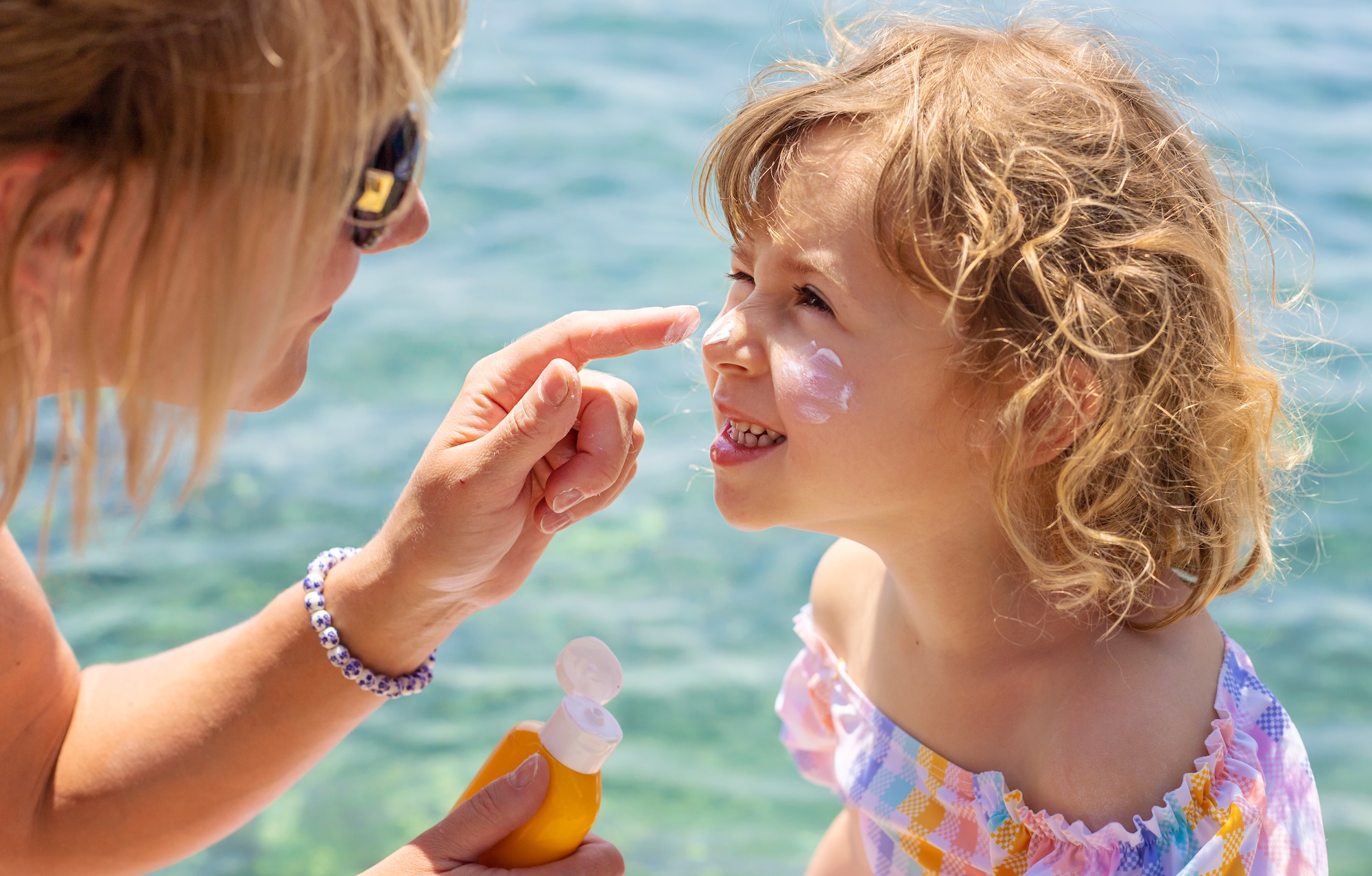 Two sunscreen bottles side by side representing chemical and mineral formulations