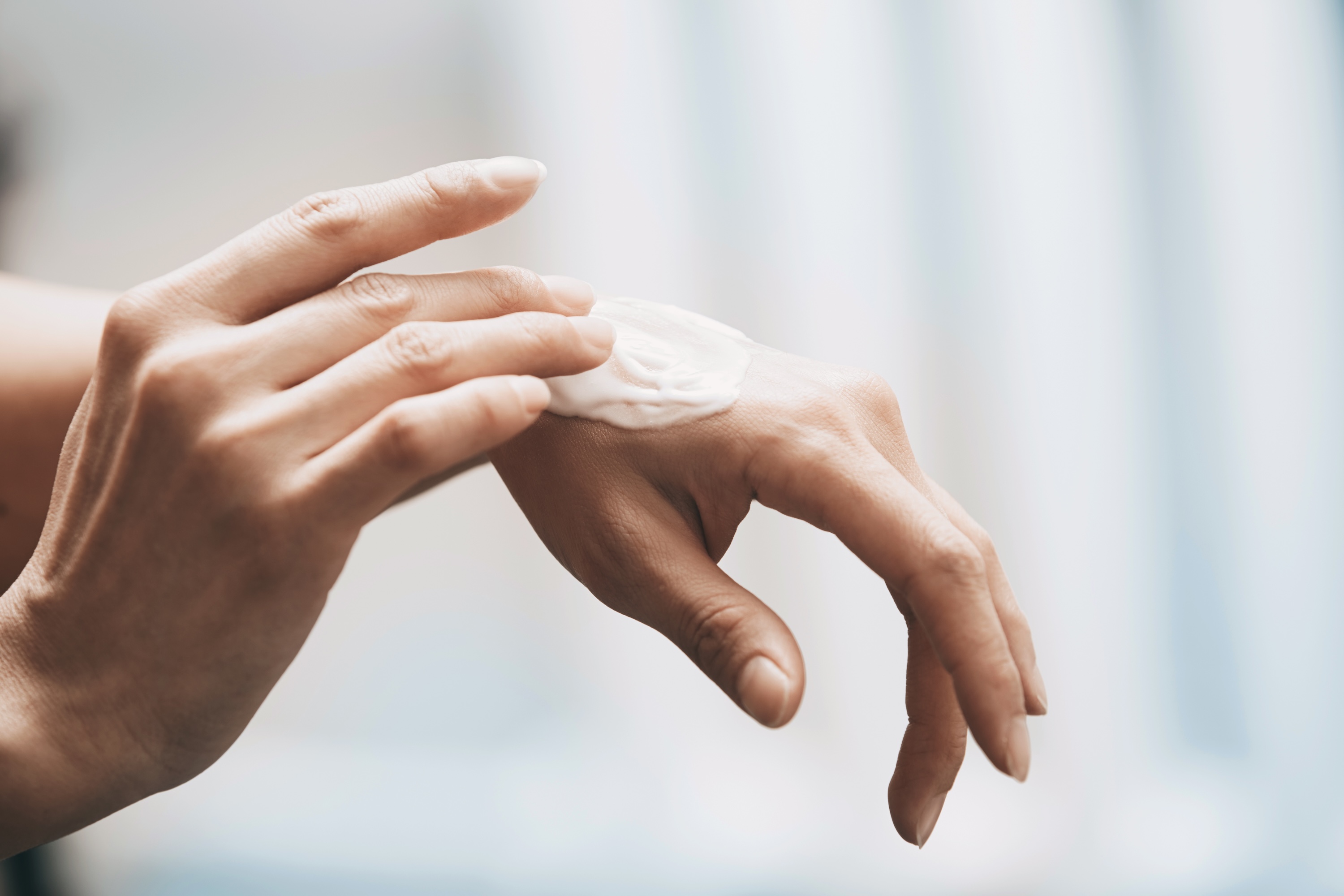 Woman applying moisturizer to her hand